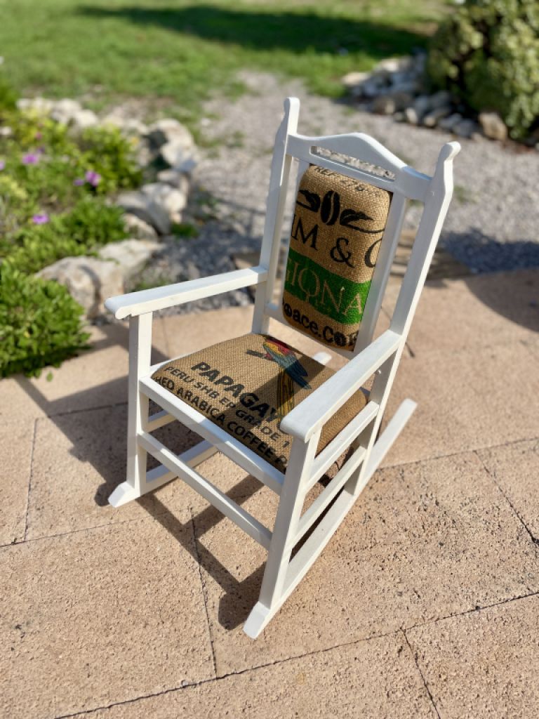 Decorative antique child's rocking chair upholstered with a coffee sack