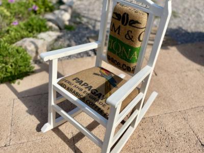 Decorative antique child's rocking chair upholstered with a coffee sack