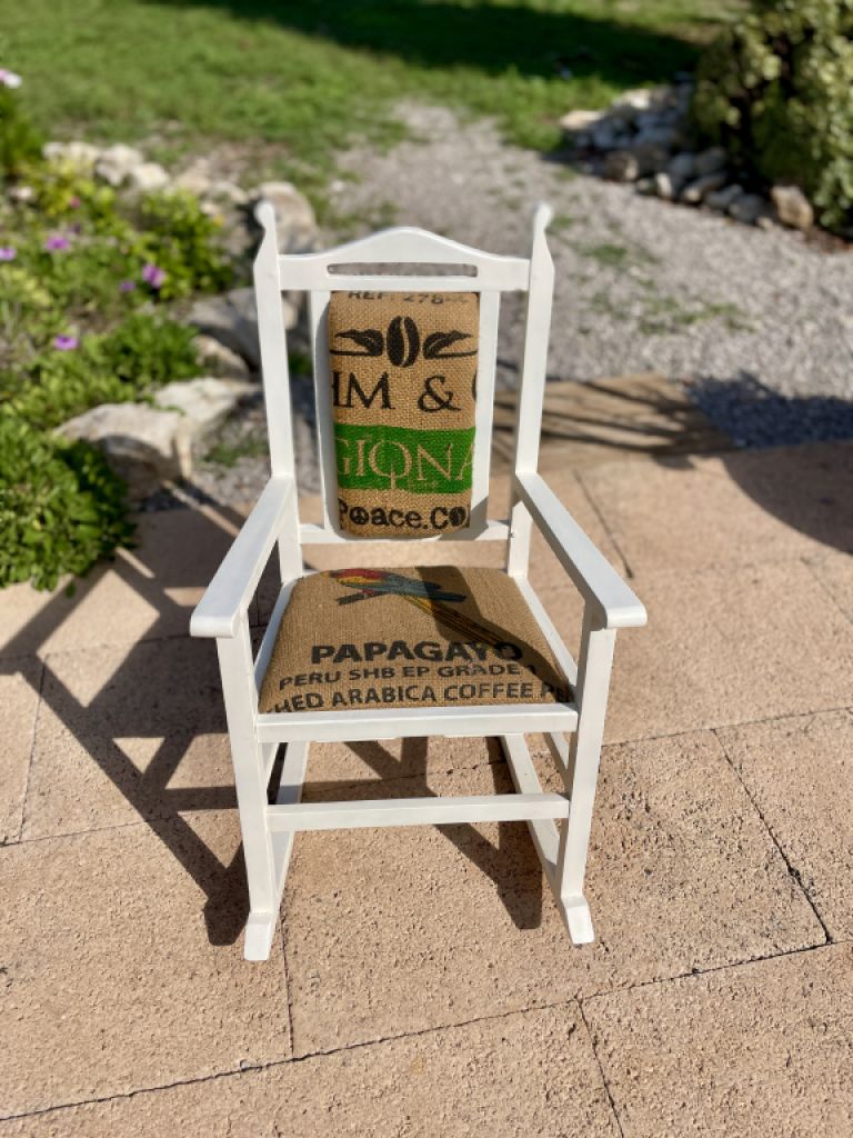 Decorative antique child's rocking chair upholstered with a coffee sack