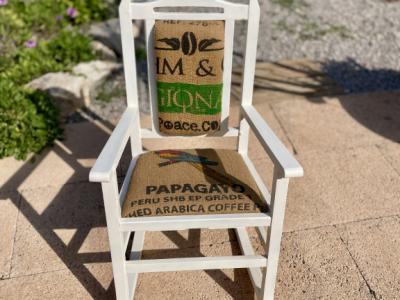 Decorative antique child's rocking chair upholstered with a coffee sack