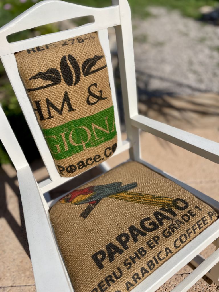 Decorative antique child's rocking chair upholstered with a coffee sack