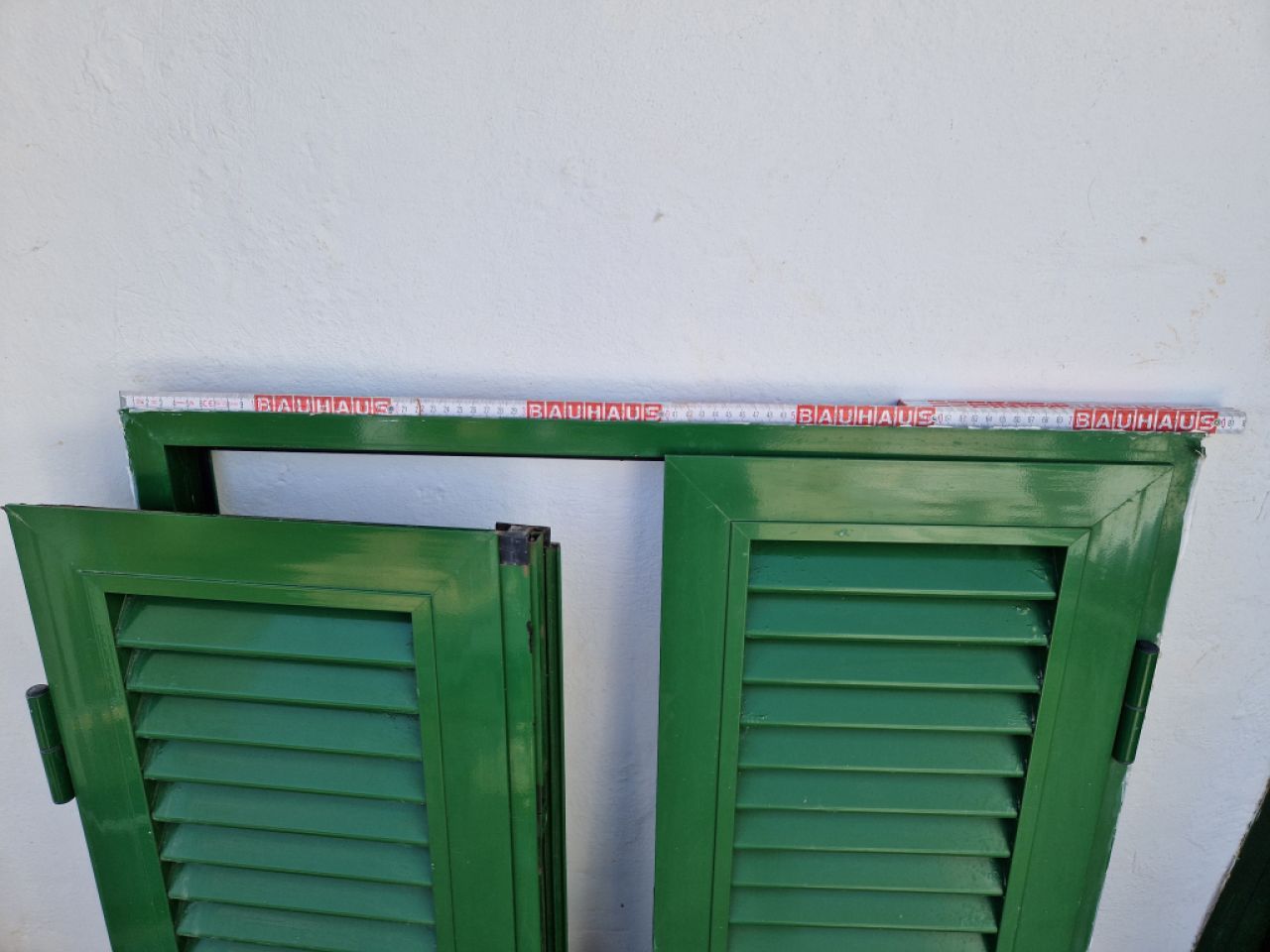 Green Persianas (shutters) made of aluminum.