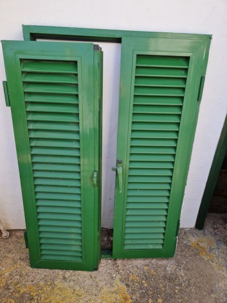 Persianas verdes (contraventanas) de aluminio.