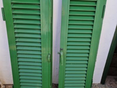 Persianas verdes (contraventanas) de aluminio.