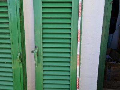 Persianas verdes (contraventanas) de aluminio.