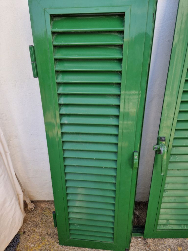 Persianas verdes (contraventanas) de aluminio.