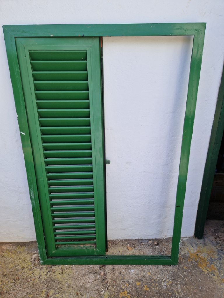 Persianas verdes (contraventanas) de aluminio.