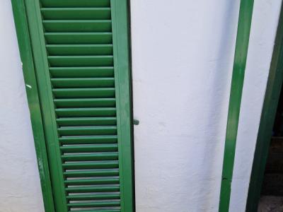 Persianas verdes (contraventanas) de aluminio.