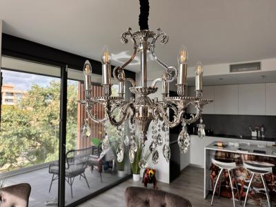 Vendo mi elegante candelabro de diseño clásico con colgantes de cristal relucientes.